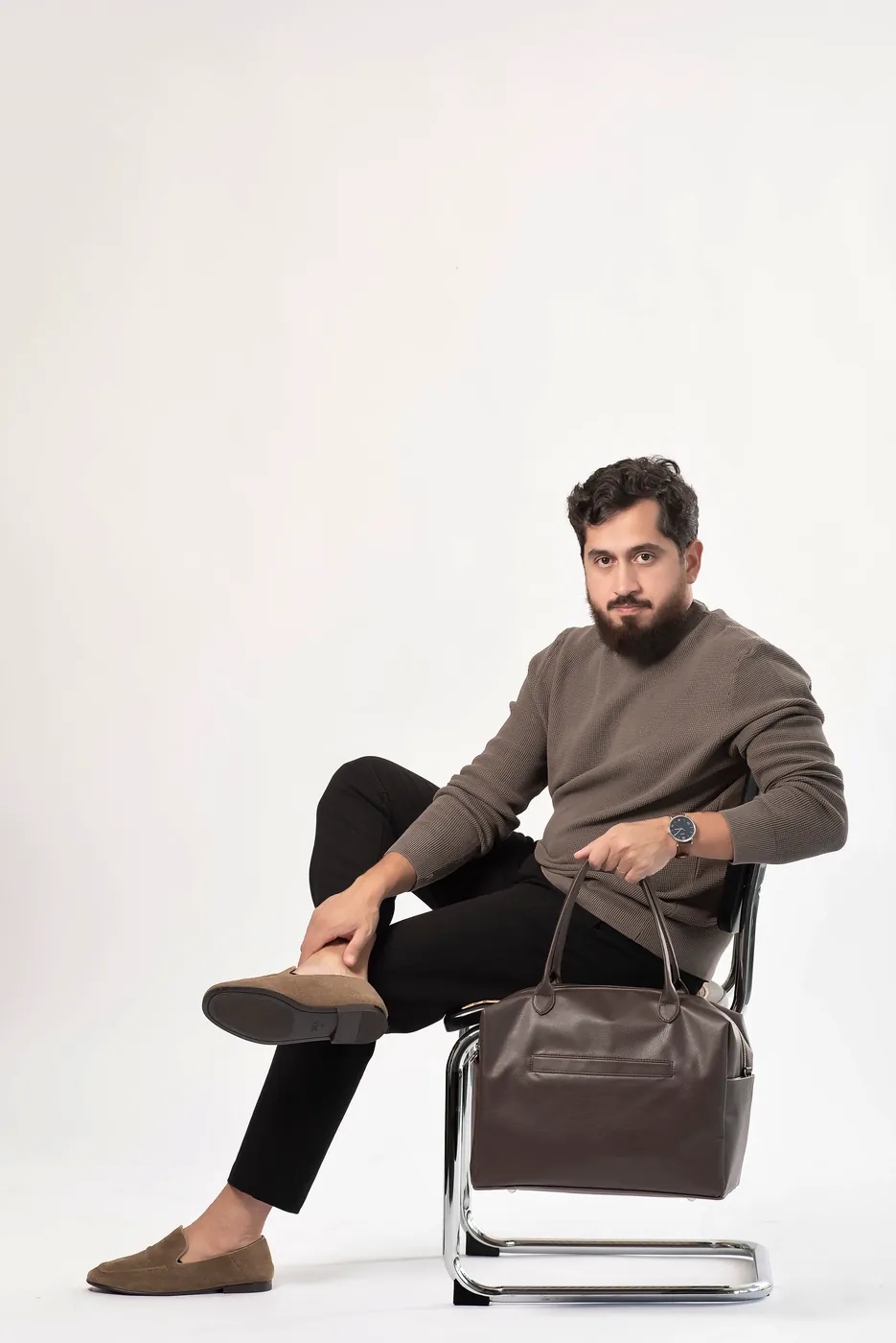 Professor Bruno sentado com uma bolsa marrom